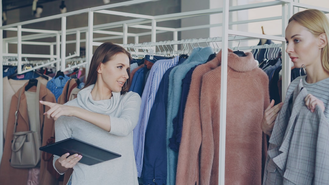 A woman helps another pick out clothes.